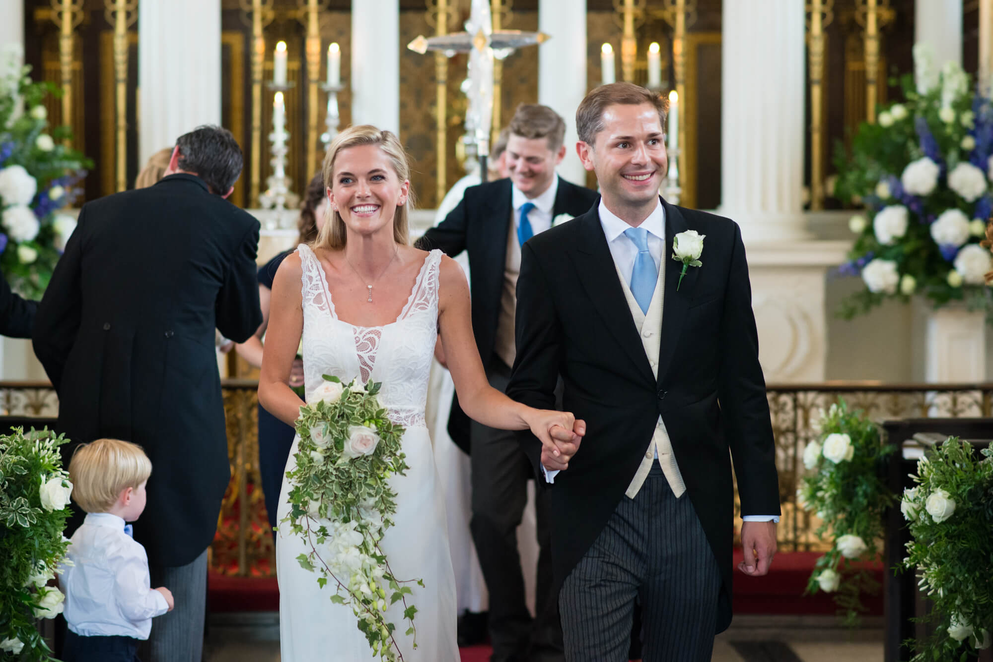 A bride and groom holding hands at the alter of the Grosvenor Chapel, London
